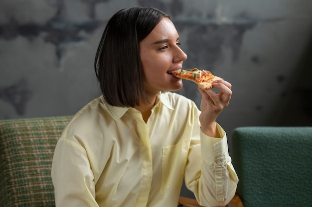 Coup moyen femme mangeant une délicieuse pizza