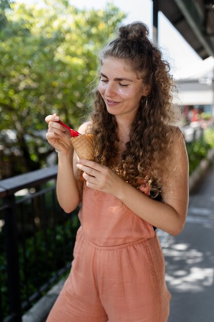 Coup moyen femme mangeant de la glace avec une cuillère