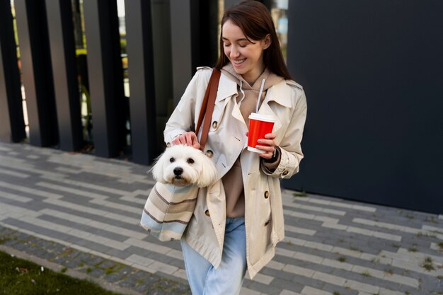 Coup moyen femme portant un chiot dans un sac