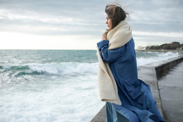 Coup moyen femme portant un foulard au bord de la mer
