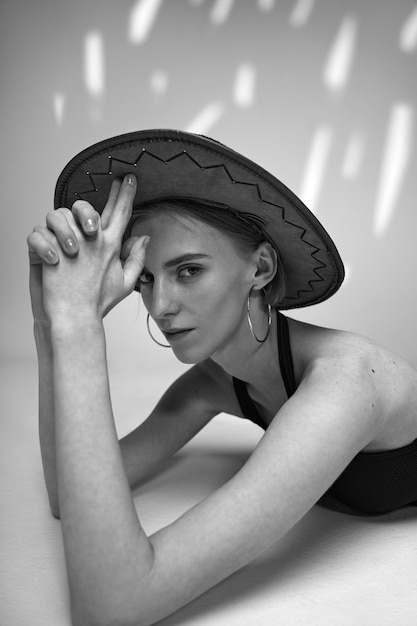 Coup moyen femme posant avec un chapeau noir et blanc