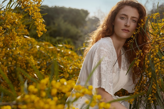 Coup moyen femme posant avec une fleur de steppe