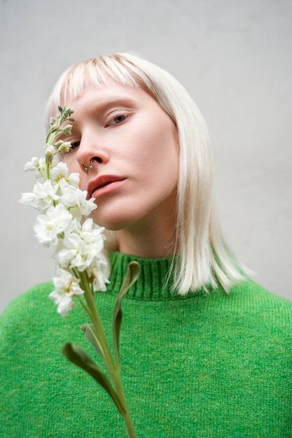 Coup moyen femme posant avec une fleur