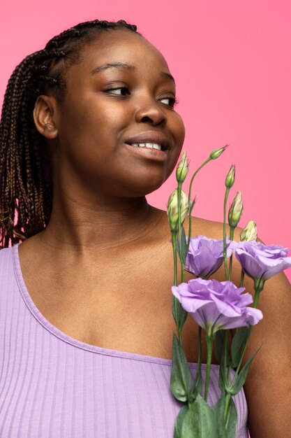 Coup moyen femme posant avec des fleurs