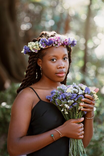 Coup moyen femme posant avec des fleurs