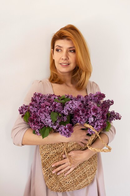 Coup moyen femme posant avec panier de fleurs