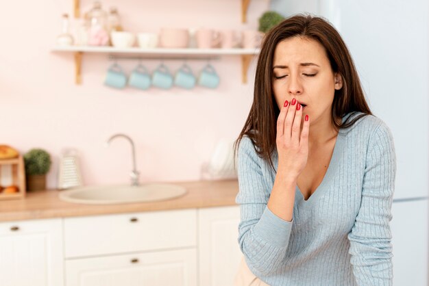 Coup moyen femme qui tousse dans la cuisine