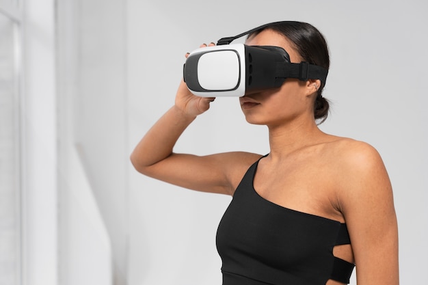 Coup moyen femme s'entraînant avec des lunettes vr sur