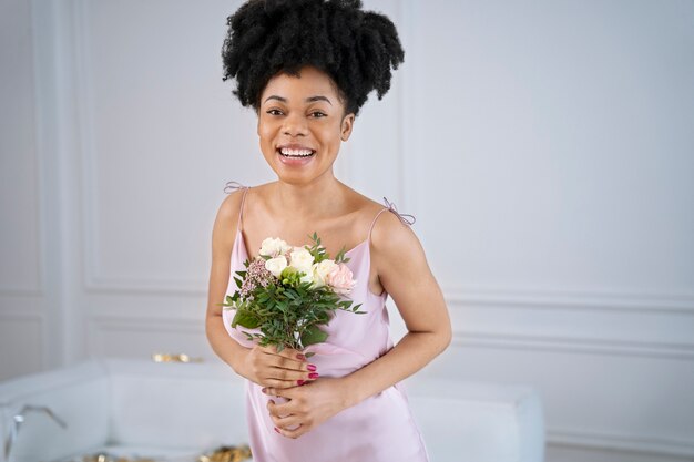 Coup moyen femme souriante tenant un bouquet