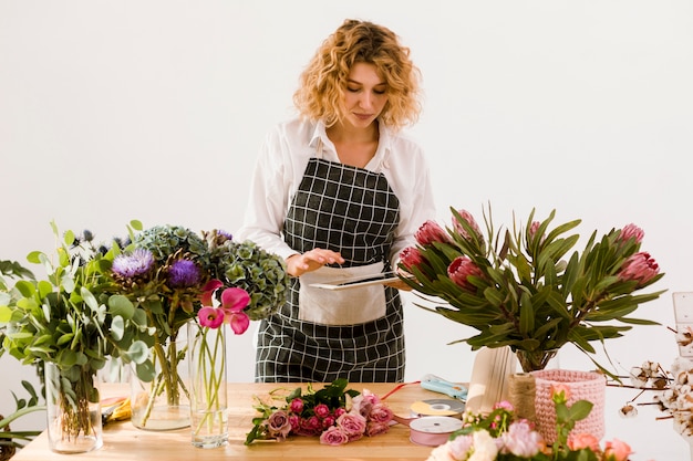 Photo gratuite coup moyen femme avec tablette dans le magasin de fleurs