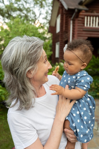 Photo gratuite coup moyen femme tenant bébé