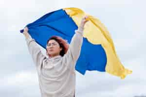 Photo gratuite coup moyen femme tenant le drapeau ukrainien