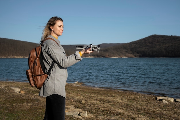 Photo gratuite coup moyen femme tenant un drone à l'extérieur