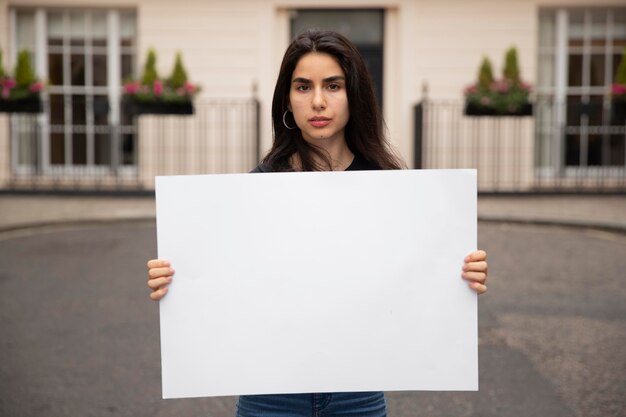 Coup moyen femme tenant une pancarte vide