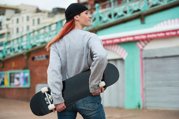 Coup moyen femme tenant une planche à roulettes