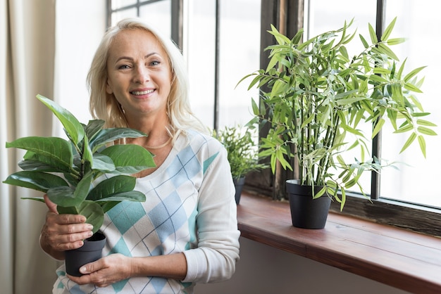 Coup moyen femme tenant une plante