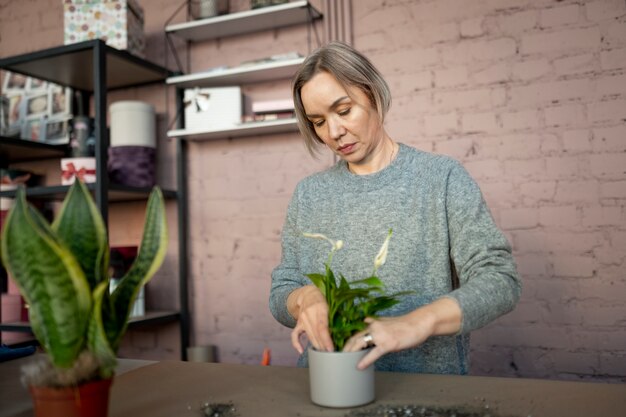 Coup moyen femme tenant un pot de fleur