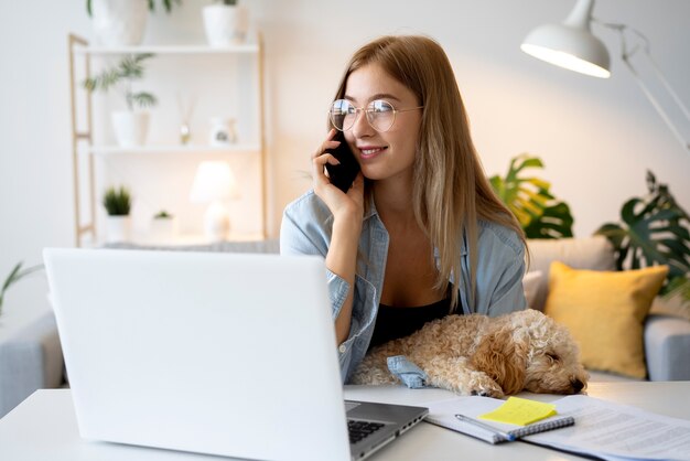 Coup moyen femme travaillant avec un chien à la maison