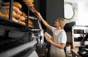 Photo gratuite coup moyen femme travaillant dans une boulangerie