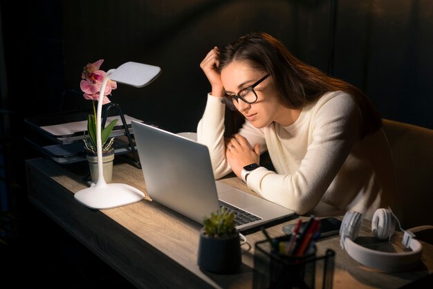 Coup moyen femme travaillant tard dans la nuit