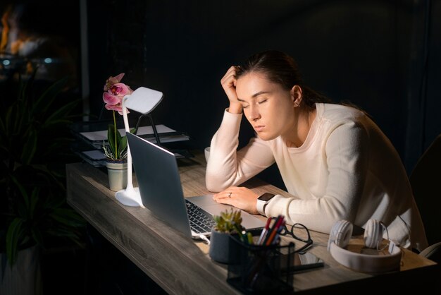 Coup moyen femme travaillant tard dans la nuit