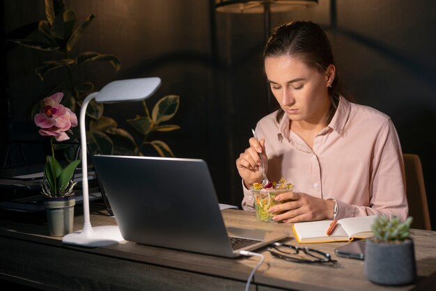 Photo gratuite coup moyen femme travaillant tard dans la nuit