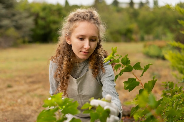 Photo gratuite coup moyen femme vérifiant les feuilles