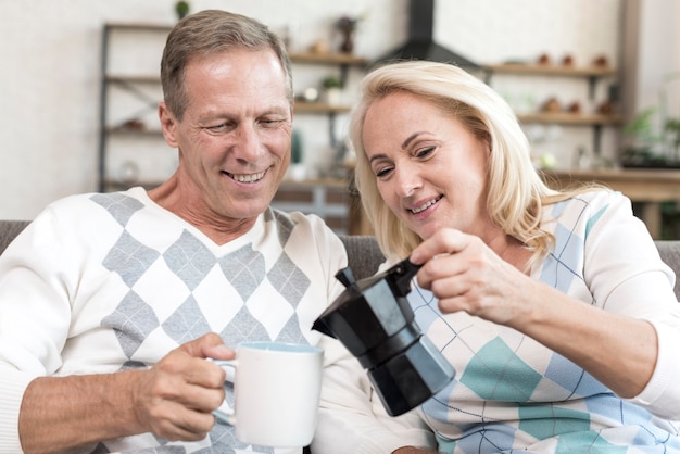 Coup moyen femme versant du café à l'homme