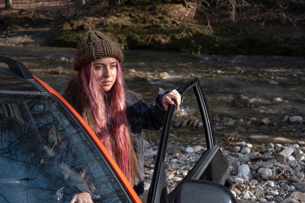 Coup moyen femme avec voiture à l'extérieur