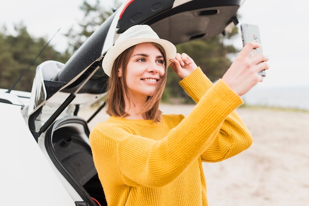 Coup moyen de femme voyageant prenant un selfie