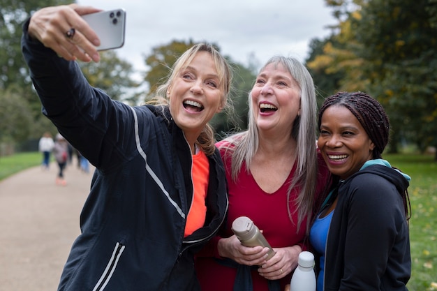 Coup moyen femmes heureuses prenant selfie