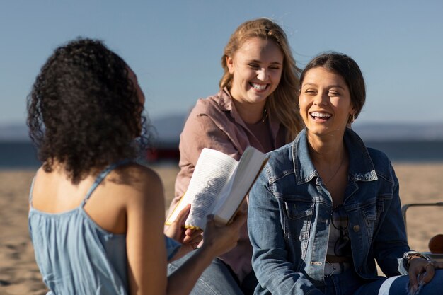 Coup moyen femmes lisant à la plage