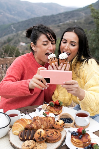 Photo gratuite coup moyen femmes mangeant des cupcakes