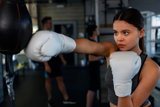 Photo gratuite coup moyen fille apprenant la boxe