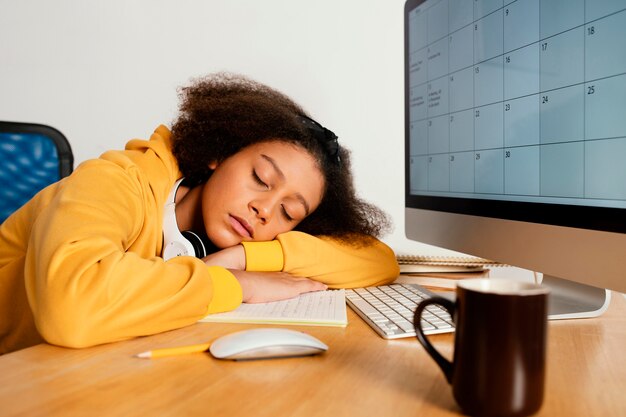 Coup moyen fille dormant sur le bureau