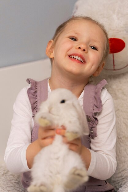 Coup moyen fille jouant avec un lapin