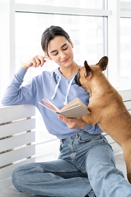 Coup moyen fille lisant près de chien