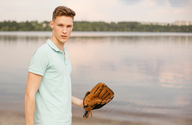 Photo gratuite coup moyen avec un gant de baseball près du lac