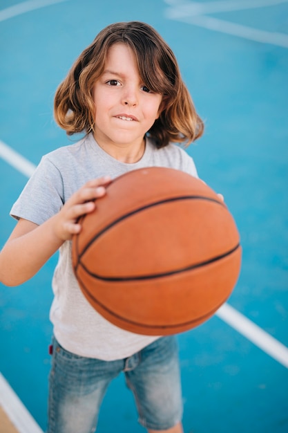 Coup moyen de garçon jouant au basketball