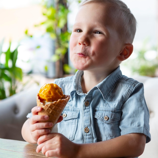 Coup Moyen Garçon Mangeant De La Crème Glacée