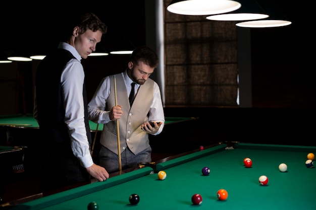 Coup moyen gars au billard club avec les smartphones