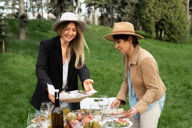 Photo gratuite coup moyen de gens heureux avec de la nourriture à l'extérieur