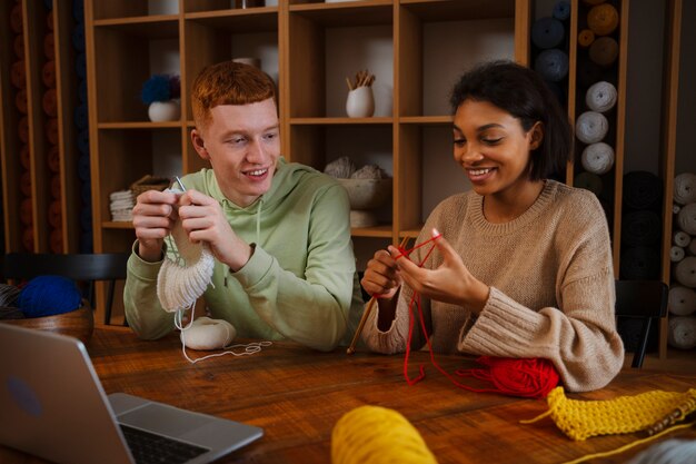 Coup moyen de gens souriants qui tricotent ensemble