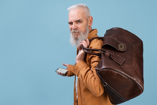 Photo gratuite coup moyen homme âgé portant des bagages bruns