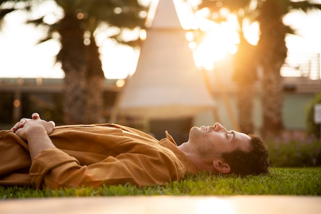 Photo gratuite coup moyen homme allongé sur l'herbe