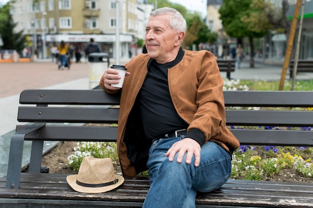 Photo gratuite coup moyen homme assis sur un banc