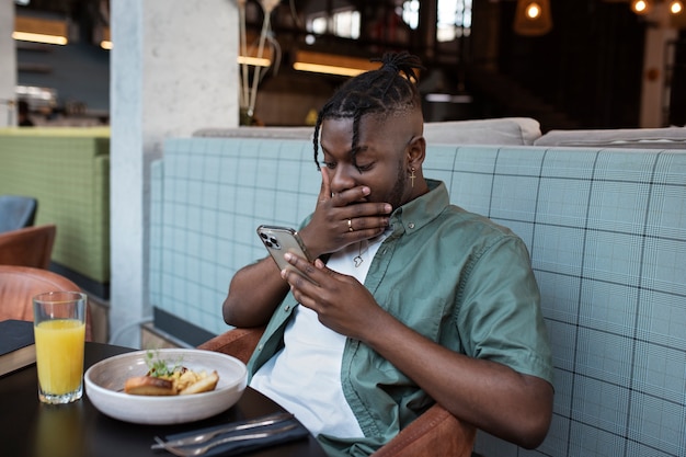 Photo gratuite coup moyen homme assis dans un café