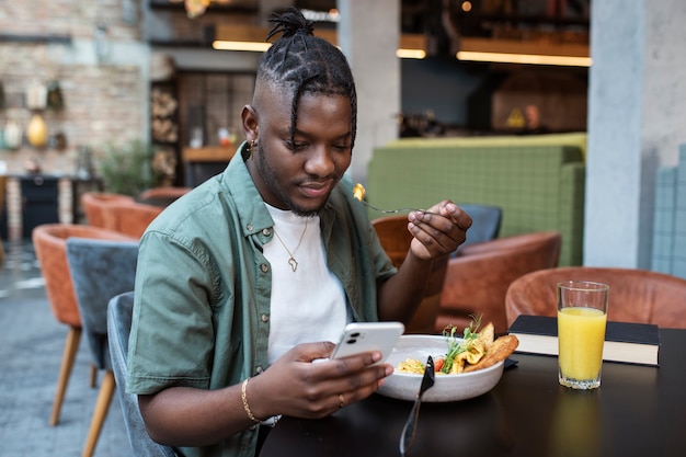 Photo gratuite coup moyen homme assis dans un café