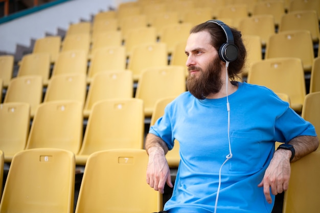 Photo gratuite coup moyen homme assis sur les tribunes