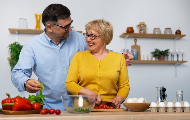 Coup moyen homme et femme cuisinant dans la cuisine